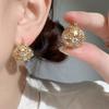 Pendientes con hebilla de oreja de cesta de flores hueca de alta gama europea y americana, diseño de nicho para mujer, ligeros, elegantes, de Internet, estilo frío, accesorios para las orejas para mujer