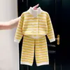 Ropa infantil estilo coreano 2026 otoño nuevo conjunto de punto a rayas amarillas y blancas suéter de cuello alto de doble botonadura para niños y pantalones de pierna ancha