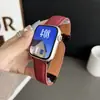 Patrón de manzana y lichi cierre plegable correa de cuero de doble cara para iWatch 11 10. La correa es negra con un cierre plateado, proporcionando transpirabilidad para la muñeca.