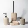 Conjunto de Quatro Peças para Banheiro com Superfície de Concreto: Frasco de Loção, Escova de Vaso Sanitário, Copo, Artigos de Higiene Pessoal, Cimento, Uso Doméstico