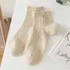 Calcetines cortos de encaje de color liso con lazo para mujer, calcetines de algodón de malla fina hueca transpirables que absorben el sudor de tubo medio para estudiantes