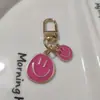 Llavero de cara sonriente de color aleación con goteo transfronterizo de comercio electrónico, accesorios de colgante para bolso con expresión irregular chapado en oro