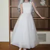 Vestido largo de malla blanco puro con cuello redondo, sin mangas, cintura ceñida y lazo