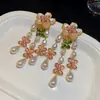 Brincos de flor de resina cravejados de diamantes e pérolas, em estilo de corte francês, exalando uma aura luxuosa e sofisticada, criando um visual suave e elegante.