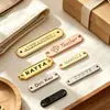 Personalización de letrero con LOGOTIPO # Insignia metálica de aleación de zinc fundido a presión con doble ojal cosido para decoración de chaqueta cortavientos