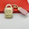 Capa exterior con marca famosa dorada, colgante de llavero de alta gama transfronterizo, regalo para la industria de la belleza, regalo para impulsar el tráfico en transmisiones en vivo, recuerdo para clientes