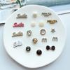 Pequeño Estilo Chanel Taladro de Punto Sonrisa Sonrisa Inglesa Letra M Accesorios de Joyería Horquilla Pinza para el Cabello Agujero Zapatos Zapatos de Frijol Material