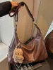 Bolsa feminina grande capacidade nova de outono de 2026, bolsa de ombro transversal lisa e moderna, bolsa casual tipo bolinho para o dia a dia