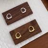 Aretes de aro liso para mujer nuevo diseño de nicho personalizado sensación de alta gama sin necesidad de dormir aretes de nudo de cuerda ins aretes de hebilla aretes de botón