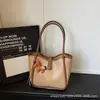 Bolsas de mano para mujer transfronterizas, nuevo modelo 2026, bolso de hombro y bandolera de alta gama a la moda para mujer, bolso de mano simple para el día a día, bolso tipo cubo