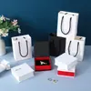 Set de joyero de alta gama con veta de madera en esquema de colores rojo y blanco, incluyendo un anillo, pendientes y pulsera, con diseños en relieve; cajas de joyería al por mayor