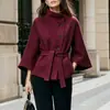 Roupas femininas transfronteiriças europeias e americanas de 2026: gola alta, fechamento diagonal por botões, mangas amplas, cintura marcada com cinto e elegante casaco de lã para o trajeto
