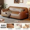 Sofá de estilo de mediados de siglo, color blanco roto, de piel sintética, con reposabrazos redondeados de forma única, cojines de asiento segmentados y diseño de pie, adecuado para una sala de estar como sofá de línea recta