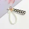 Suministra y Vende Pulseras de Cinta Rayada con Forma de Hoja de Perla de Imitación, Llaveros, Correas para Teléfono y Accesorios para Bolsas Tejidos a Mano