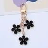 Nuevo llavero colgante de flor colorida ins, creativo, aleación DIY, flor pequeña de doble cara, decoración para funda de auriculares, bolso