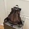 Mochila con cordón de ambiente primaveral en color caqui, con una sensación relajada, simple y casual para ir al trabajo y hacer compras