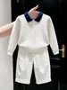Roupas infantis coreanas 2026 outono/inverno novo suéter branco de tricô com trama de cabos, gola polo, manga longa e calça casual reta