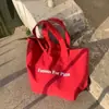 Bolsa de lona vermelha ins nicho 2026 nova casual estampa de letras lona bolsa de ombro único grande capacidade bolsa de estudante