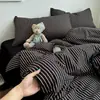 Juego de cuatro piezas de algodón acolchado con estampado de rayas minimalista con sábana bajera y funda de edredón de doble cara