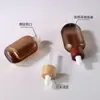 Botella de vidrio ámbar con gotero para sérum de 30 ml, tapa de madera de bambú personalizada de alta gama, para cuidado de la piel y del cabello, aceite esencial, OEM