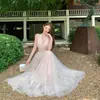 Elegante vestido rosa de malha com decote V e amarração no pescoço para mulheres, perfeito para férias na praia, criando uma atmosfera romântica e festiva, adequado como vestido de aniversário ou para ocasiões formais mais leves