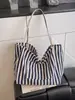 Bolso de lona a rayas verticales simple artístico estilo coreano, gran capacidad, bolso de hombro casual y versátil para mujer, transfronterizo