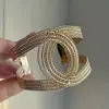 Brazalete abierto tejido de metal retorcido dorado brillante estilo antiguo vintage con un toque de alta gama