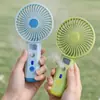 Ventilador de mano nuevo, simple y elegante, con rociador hidratante y tres velocidades de viento, que cuenta con una base de carga directa para teléfono, perfecto como ventilador de escritorio y como regalo