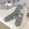 Etiqueta de tela de gatito en el talón, calcetines de media pantorrilla estilo ins coreano, calcetines holgados de color sólido de dibujos animados, calcetines de algodón para mujer sin costuras de otoño e invierno