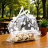 Bolsas transparentes con cordón y estampado de margaritas, adecuadas para empaques para llevar, repostería, como bolsas para pasteles o bolsas de compras de mano.