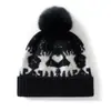 Nova coleção outono e inverno: gorro de tricô simples e versátil com pompom, feito de cashmere, apresentando um design color-block com um pequeno motivo de veado, oferecendo um visual moderno, casual e quente