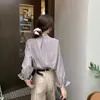 Tiro real temperamento simple francés cuello en V manga larga camisa mujer sentido del diseño nicho pliegues en los hombros botón dorado camisa 26435