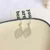 Aretes coreanos minimalistas estilo ins retro de hoja hueca con perla temperamento simple Joker aretes largos al por mayor 116