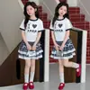 Roupa de Menina Transfronteiriça Verão 2026 Novo Estilo Vestido Xadrez de Manga Curta para Meninas Conjunto de Duas Peças Atacado