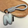 Venta al por mayor transfronteriza de llaveros japoneses y coreanos con letras en inglés, dijes para bolso de cuero dopamina, pequeños accesorios y regalos