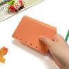 Página separadora de cuaderno A7 con núcleo de repuesto de hojas sueltas de color naranja con borde cruzado, página de índice de 6 páginas con título incorrecto.