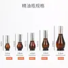 Botella spray oscura de calabaza única marrón envase de cosméticos botella de vidrio vacía botella de emulsión con dispensador marrón en stock al por mayor