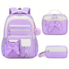 Nuevo juego de mochila escolar de tres piezas transfronteriza para estudiantes de primaria, mochila para niñas de gran capacidad con lazo, diseñada para reducir la carga, directo del fabricante