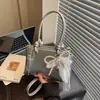 2026 Nova Bolsa Quadrada Pequena Estilo Coreano com Laço e Pingente de Pérola para Mulheres, Bolsa Transversal Fashion Versátil, Nicho de Luxo