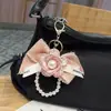 Estilo Coreano Nuevo Llavero de Coche con Lazo Bordado de Encaje Decoración Colgante de Bolsa de Cuentas Creativa Camelia Moda