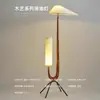 Lámpara de pie de estilo vintage, de madera maciza, para sala de estar y dormitorio, colocada junto al sofá, con almacenamiento integrado y luz de lectura de cabecera, creando una atmósfera decorativa ambiental.