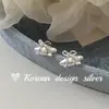 Design de nicho coreano estilo INS senso de design joias de prata brilhante S925 prata esterlina fofo croissant laço oco brincos de tarraxa