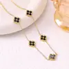 Conjunto de tres piezas de la suerte estilo europeo y americano: conjunto vintage de collar, aretes y pulsera de trébol de cuatro hojas en negro y dorado. Accesorios versátiles para el trayecto al trabajo al por mayor