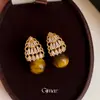 Brincos de renda vazada estilo retrô francês com zircônias cúbicas e pedras de olho de tigre, em uma paleta de cores Melard, oferecendo um visual luxuoso e sofisticado, e um acessório da moda