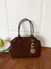 Nuevo bolso de hombro elegante para principios de otoño de 2026, bolso de mano de nicho de alto valor, bolso cruzado tipo cubo de color liso, moderno y simple