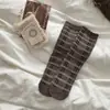 Meias estilo retrô com tema de floresta para mulheres, coleção outono/inverno, feitas com algodão de Xinjiang, meias sem costura de altura média, apresentando um padrão xadrez em blocos de cor e um design moderno em camadas