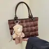 Bolsa transversal de ombro único estilo coreano para outono, bolsa tote diária com pingente, novo estilo para o trabalho para mulheres, design doce e fofo 2026, com estampa xadrez e motivos de desenhos animados adoráveis