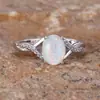 Anillo ovalado de ópalo más vendido transfronterizo, con un diseño de banda retorcida y detalles de ópalo engastados con diamantes.