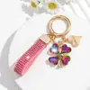 Bestseller transfronterizo europeo y americano: Lujoso llavero de trébol de cuatro hojas con adornos de diamantes completos, brillante y elegante, con un colgante de cordón de cuero