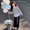 Conjunto de duas peças estilo colegial para meninas mais velhas, apresentando um top patchwork e calça casual xadrez com blocos de cor, um look versátil e moderno
